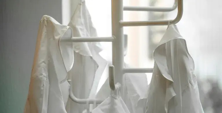 Witte jas aan de kapstok