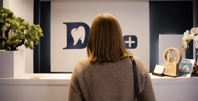 Vrouw van achterkant in tandartspraktijk