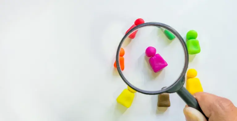 Verschillende gekleurde pionnetjes onder een vergrootglas