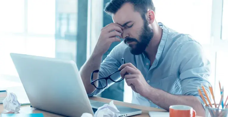 Een gespannen man achter zijn laptop