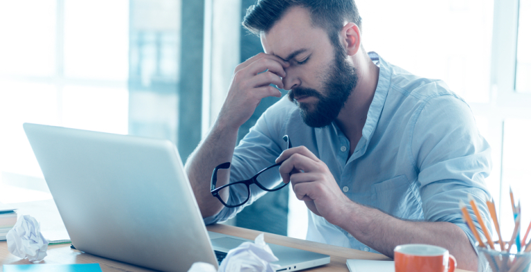 Een gespannen man achter zijn laptop