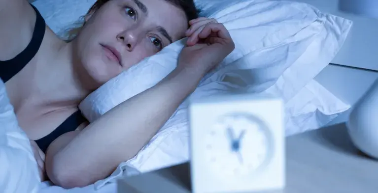 Vrouw ligt wakker te piekeren in bed