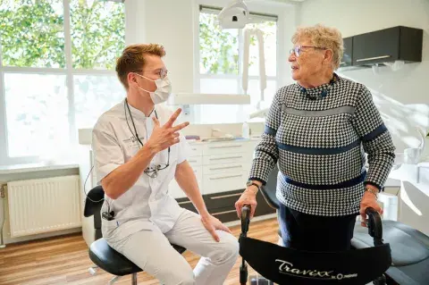 Een tandarts geeft uitleg aan zijn patiënt