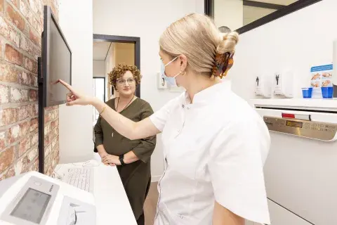 tandarts legt patient iets uit