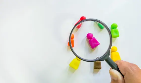 Verschillende gekleurde pionnetjes onder een vergrootglas