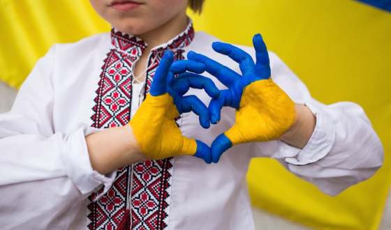 Persoon vormt hartje met handen geverfd in kleuren van Oekraïnse vlag