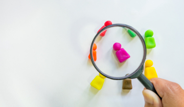 Verschillende gekleurde pionnetjes onder een vergrootglas