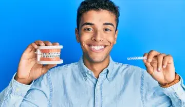 jonge man laat 2 beugels zien