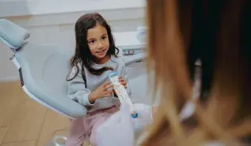 Een jong meisje krijgt voorlichting over mondverzorging