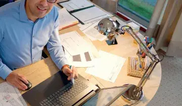 Tandarts Sepand Manouchehr achter zijn bureau na de verbouwing van zijn nieuwe praktijk